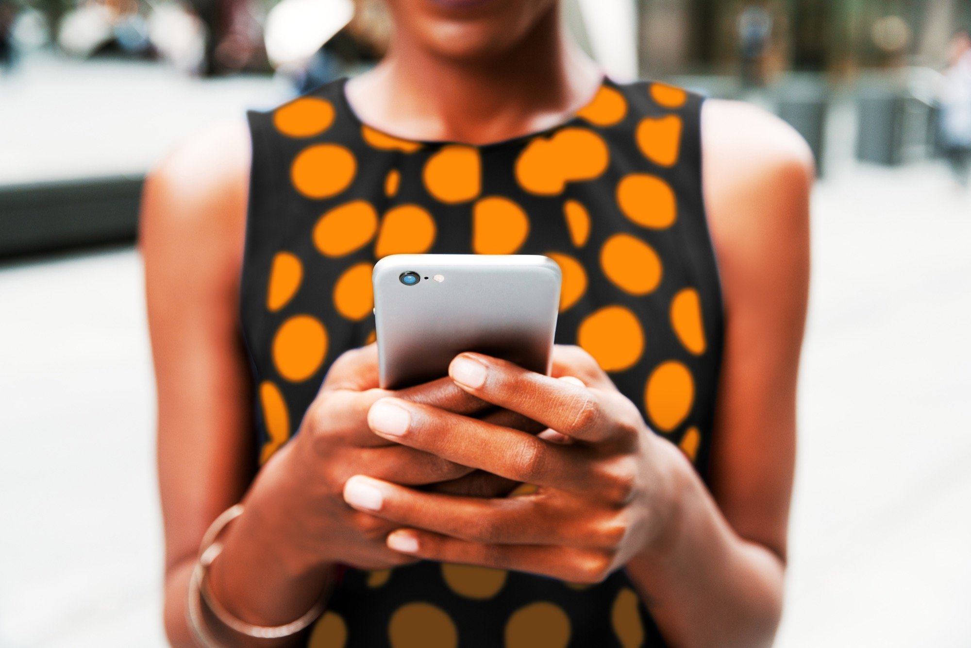 SYC Female holding phone- orange dots