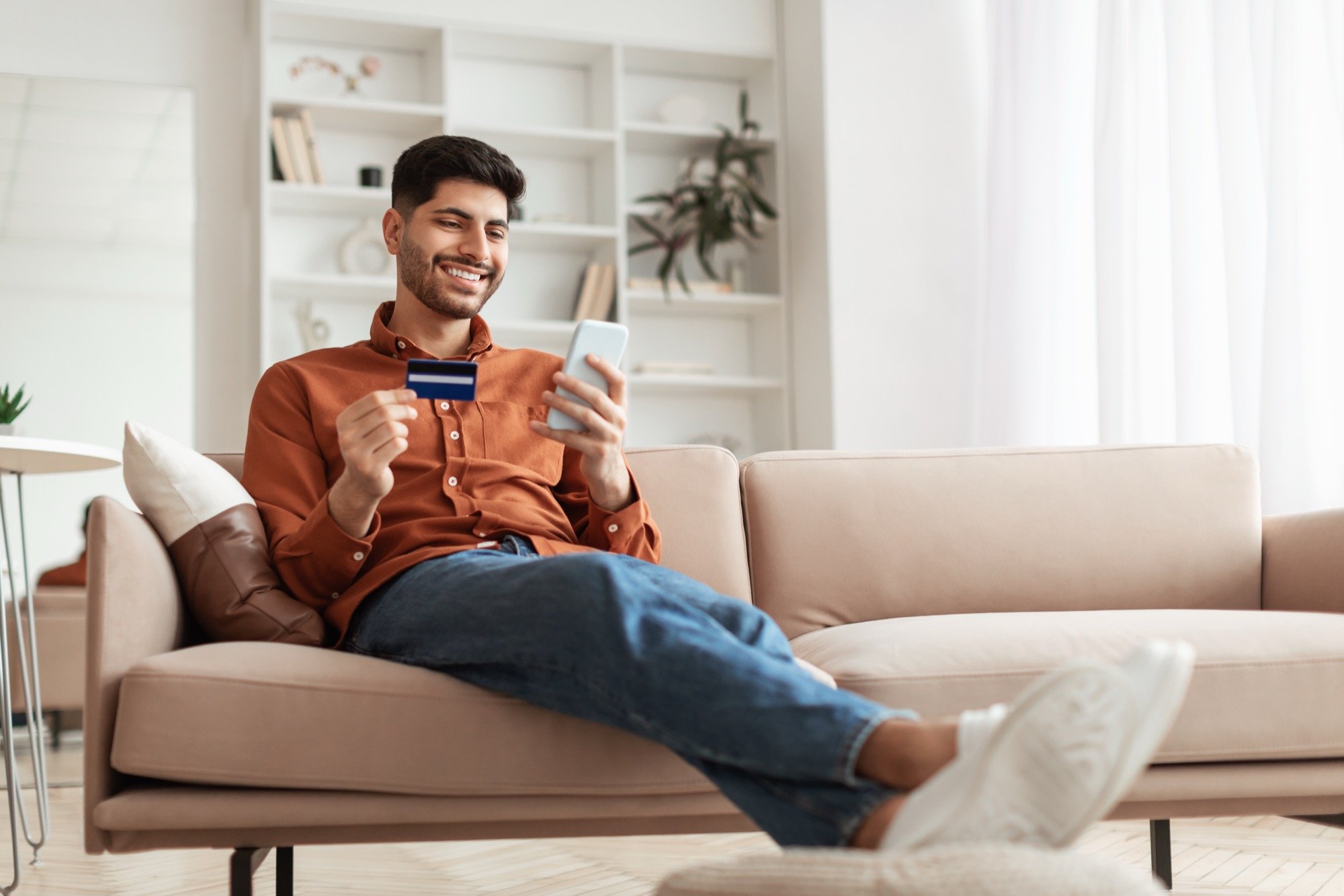 Male on sofa phone card transaction- Orange